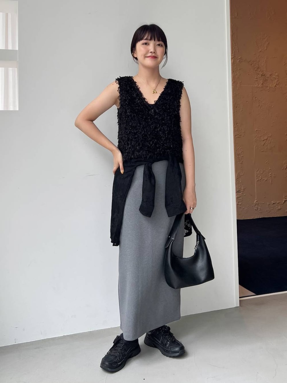 ブラック系のショルダーバッグ、ブラック系のシャツ/ブラウス、ブラック系のベストを着用したレディースの夏コーディネートの5枚目の写真