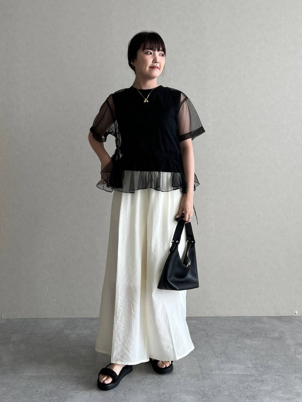 ブラック系のサンダル、ブラック系のショルダーバッグ、ブラック系のTシャツ/カットソーを着用したレディースの夏コーディネートの3枚目の写真