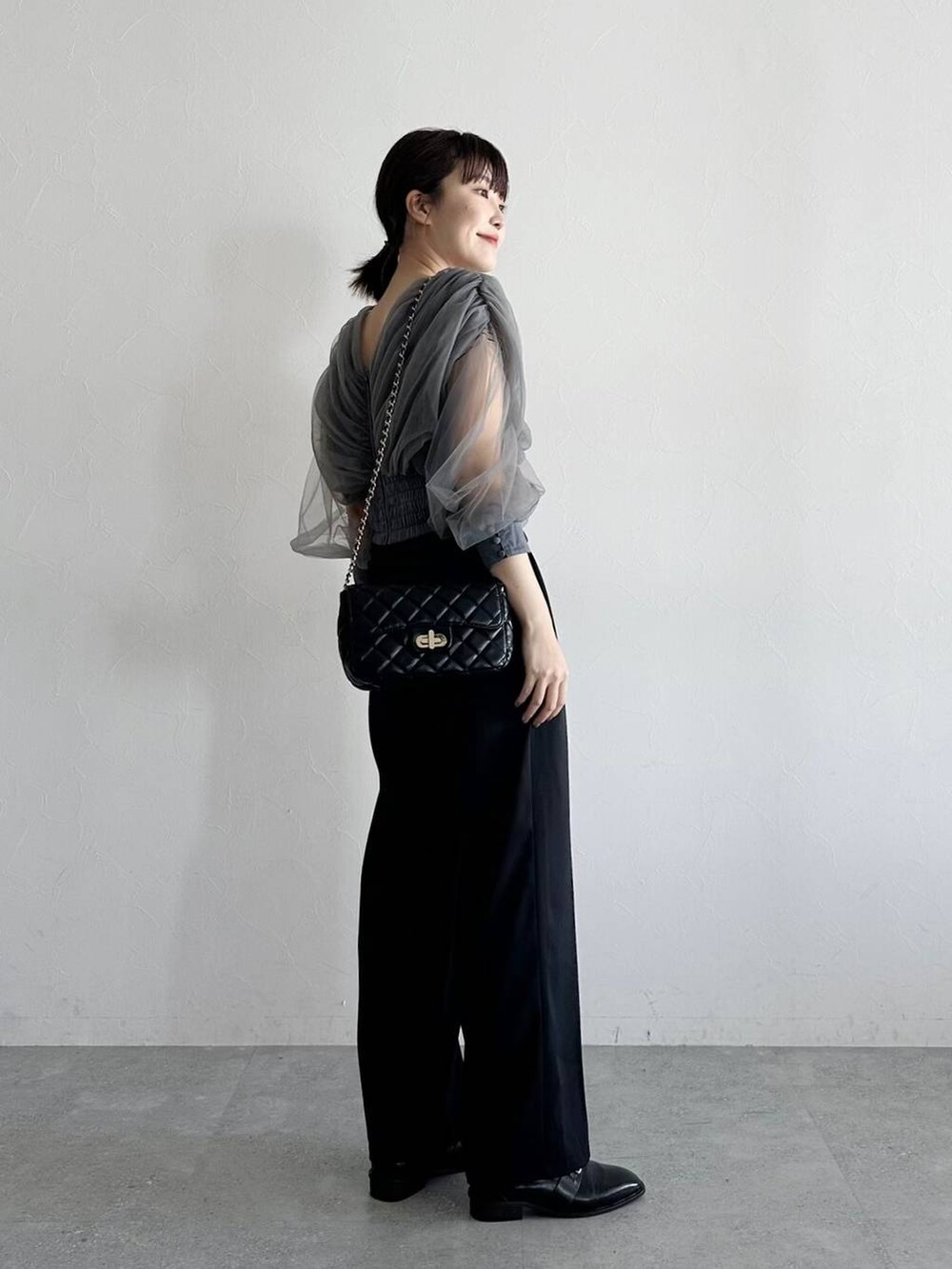 ブラック系のローファー、グレー系のTシャツ/カットソー、ブラック系のショルダーバッグを着用したレディースの春コーディネートの3枚目の写真