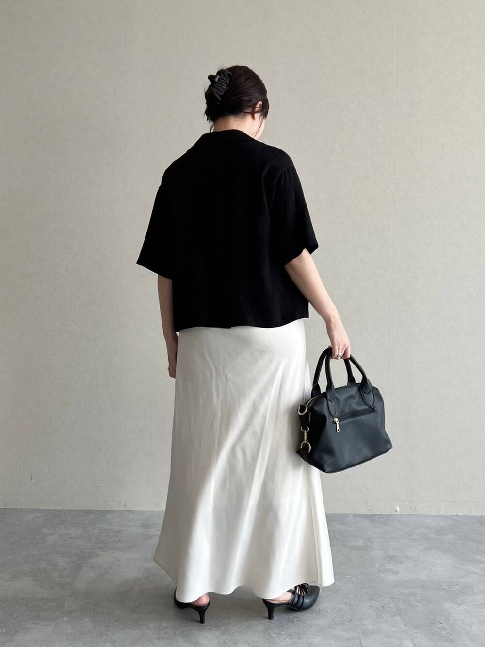 ブラック系のテーラードジャケット、ホワイト系のTシャツ/カットソー、ホワイト系のスカートを着用したレディースの夏コーディネートの2枚目の写真