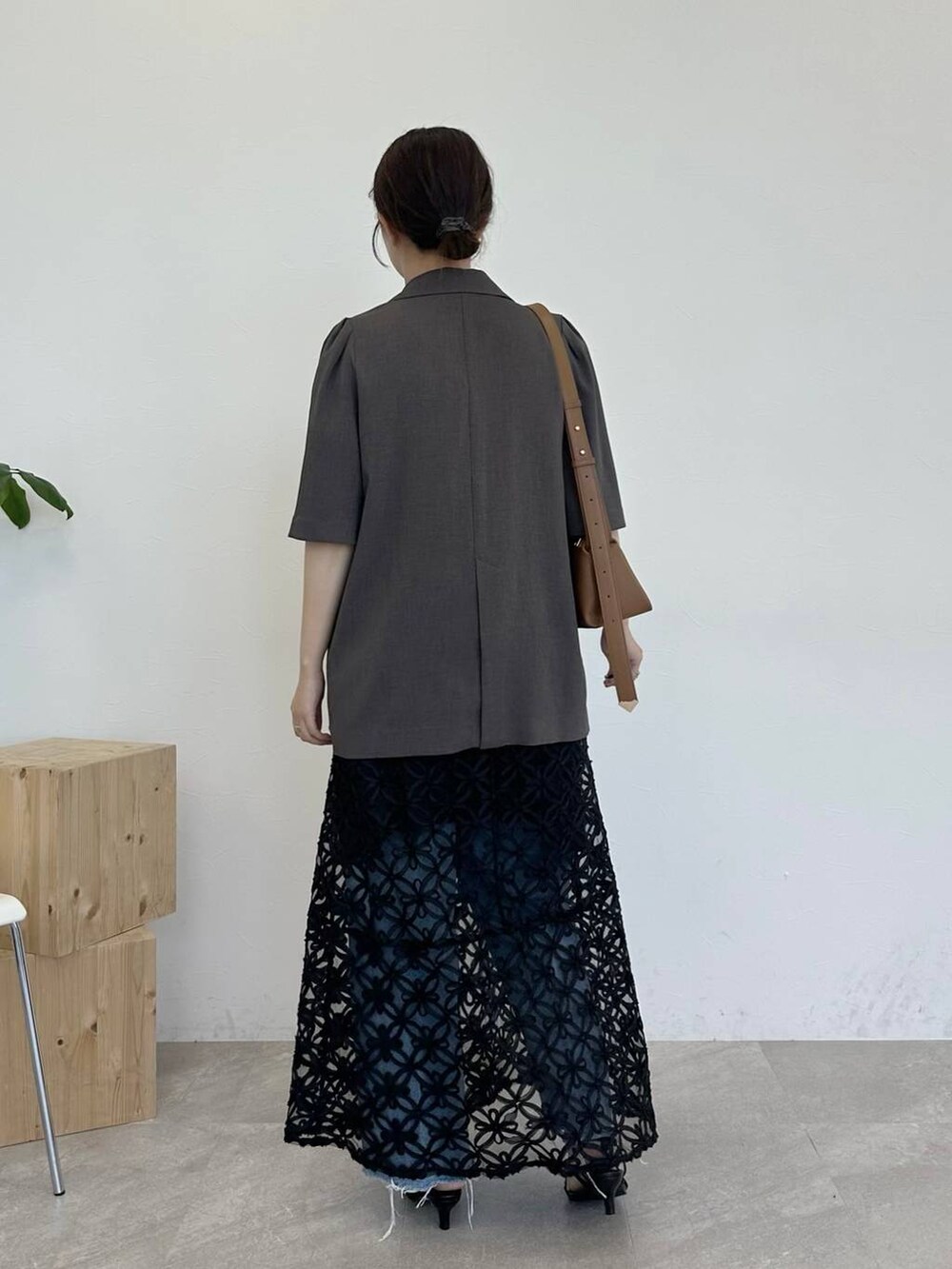 ブラウン系のテーラードジャケット、ブラック系のサンダル、ブラウン系のショルダーバッグを着用したレディースの夏コーディネートの3枚目の写真