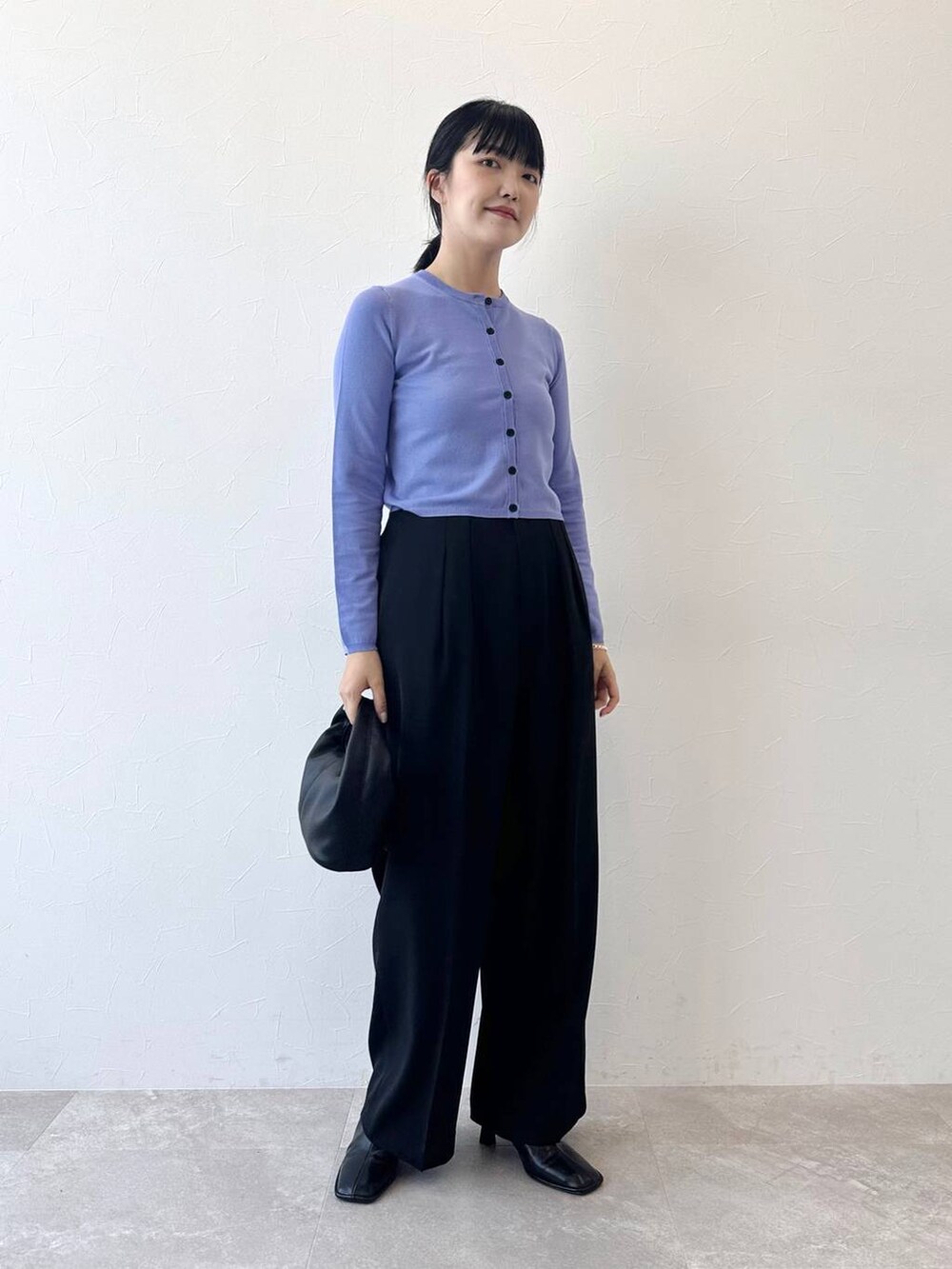 ブラック系のキャミソール、ブラック系のハンドバッグ、ブルー系のカーディガン/ボレロを着用したレディースの夏コーディネートの3枚目の写真