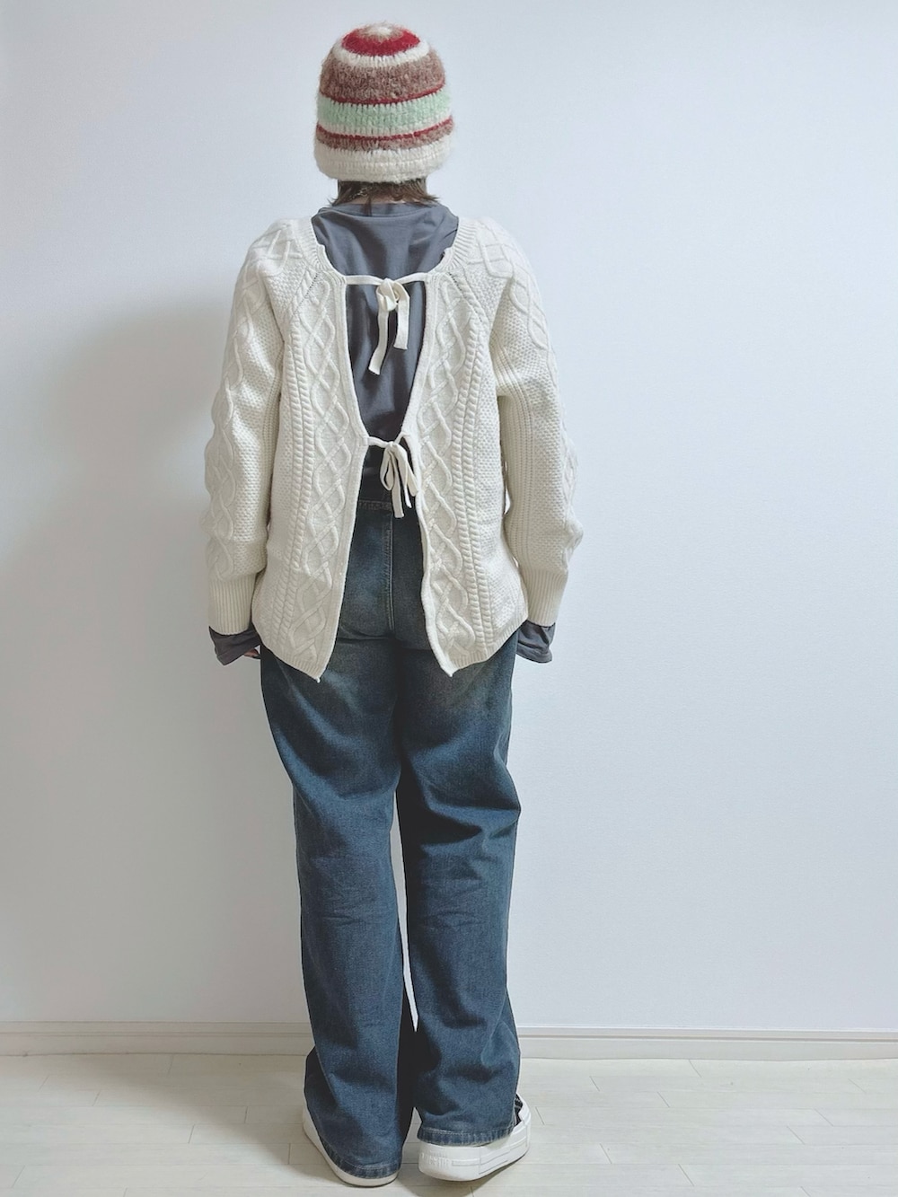 ベージュ系のニット/セーター、ブルー系のデニムパンツ、ブラック系のスニーカーを着用したレディースの冬コーディネートの3枚目の写真