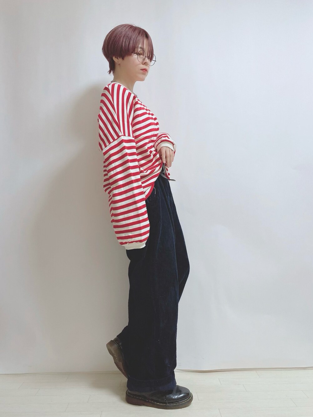 レッド系のスウェット、ブルー系のパンツ、ブラック系のブーツを着用したレディースの秋コーディネートの2枚目の写真