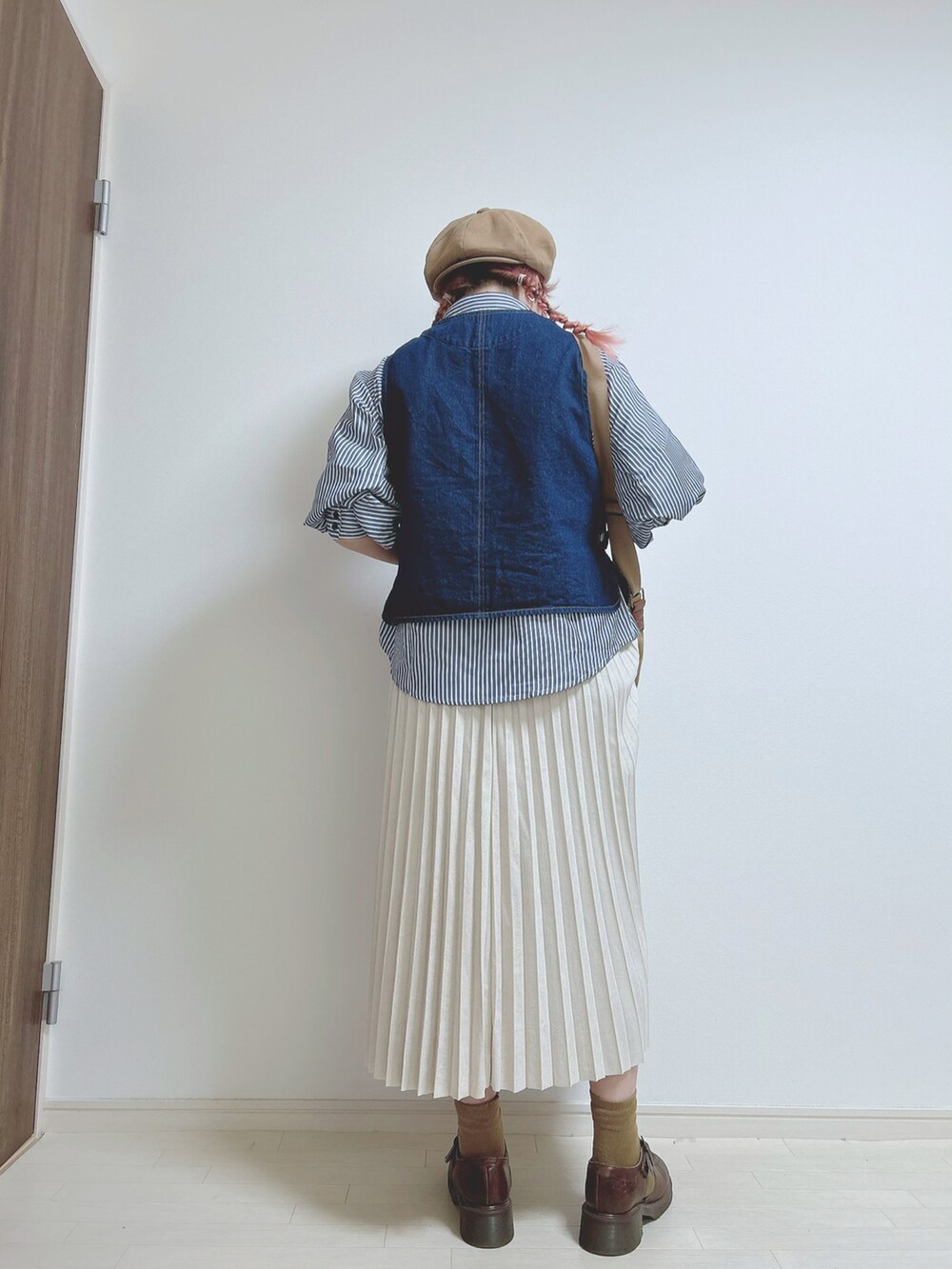 ブルー系のシャツ/ブラウス、ブルー系のベスト、ベージュ系のショルダーバッグを着用したレディースの春コーディネートの3枚目の写真