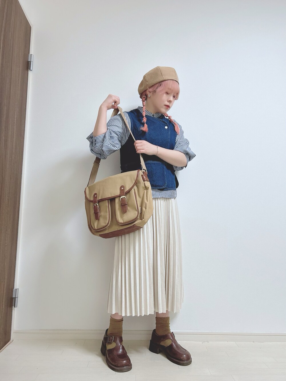 ブルー系のシャツ/ブラウス、ブルー系のベスト、ベージュ系のショルダーバッグを着用したレディースの春コーディネートの2枚目の写真