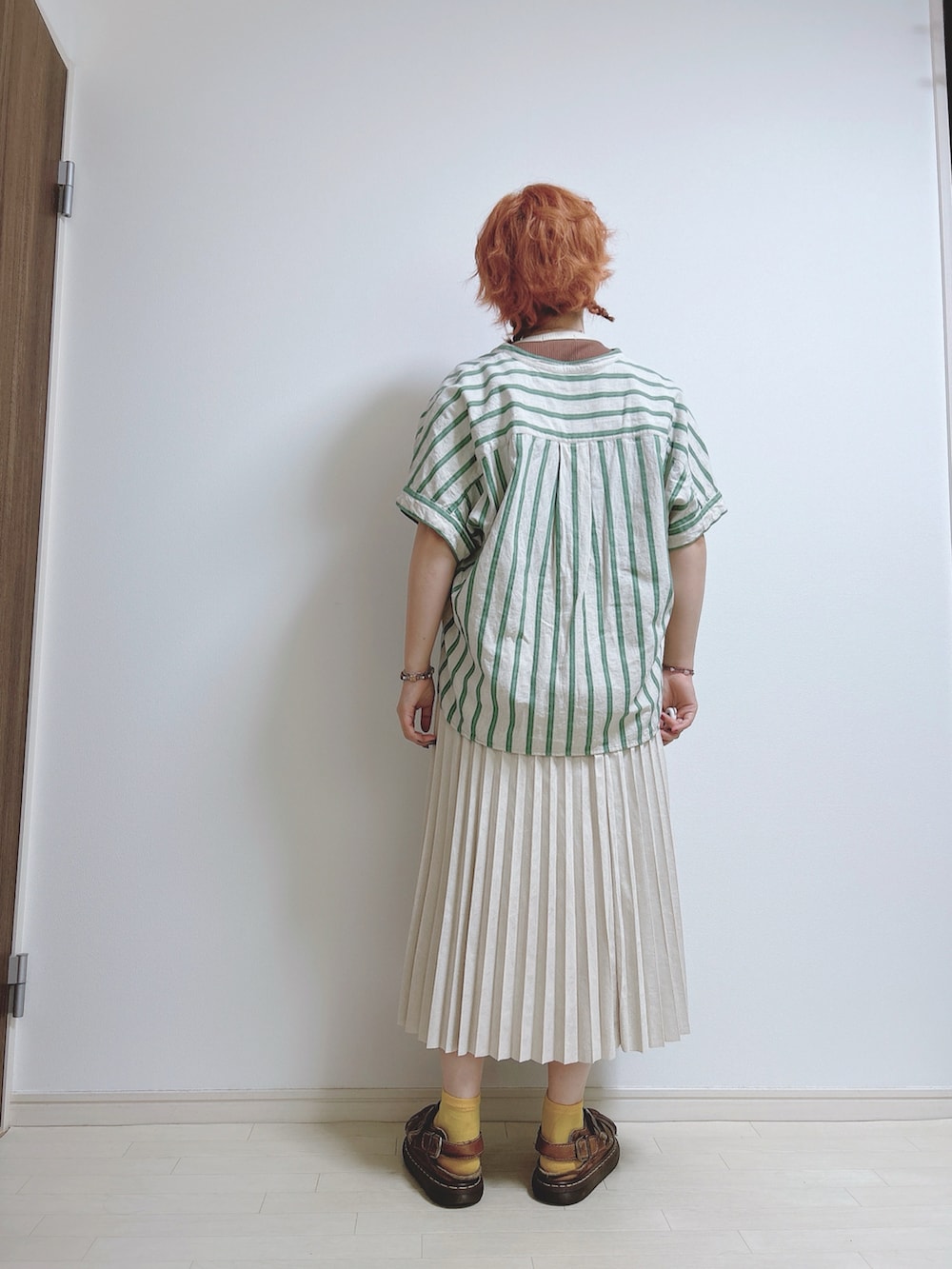 グリーン系のシャツ/ブラウス、ホワイト系のスカート、ブラウン系のサンダルを着用したレディースの夏コーディネートの3枚目の写真
