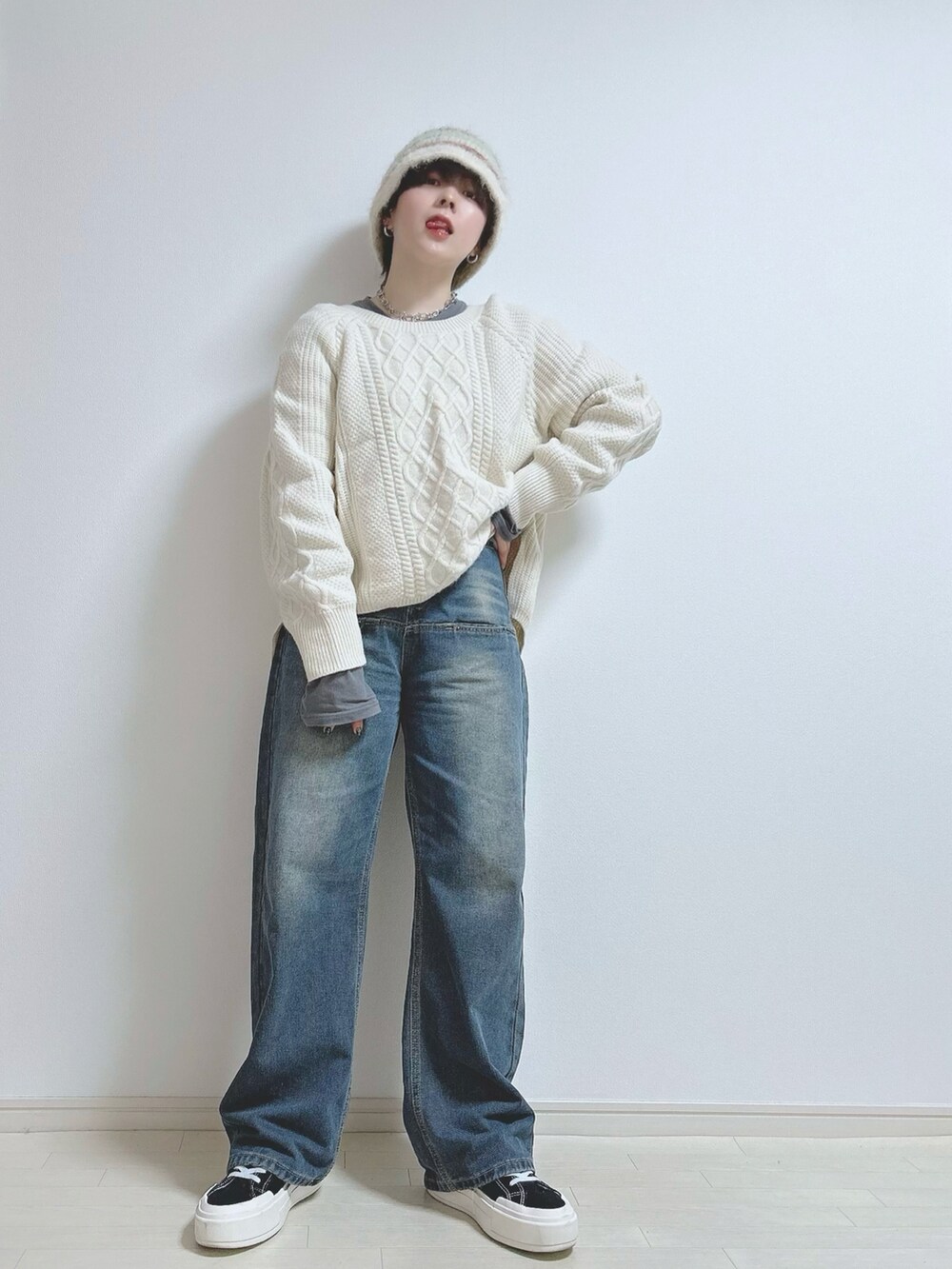 ベージュ系のニット/セーター、ブルー系のデニムパンツ、ブラック系のスニーカーを着用したレディースの冬コーディネートの2枚目の写真