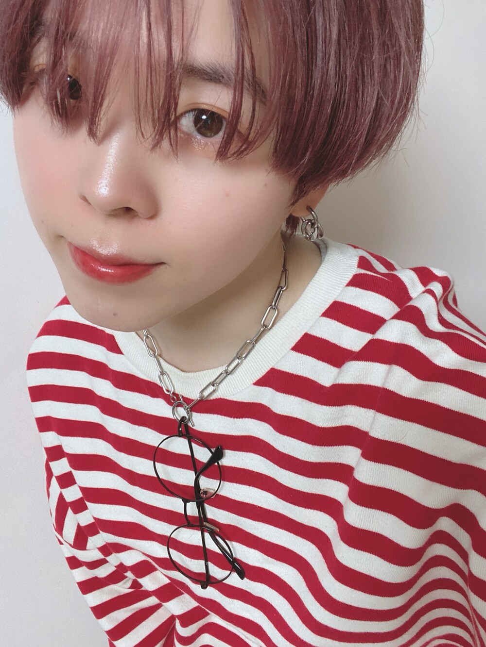 レッド系のスウェット、ブルー系のパンツ、ブラック系のブーツを着用したレディースの秋コーディネートの3枚目の写真