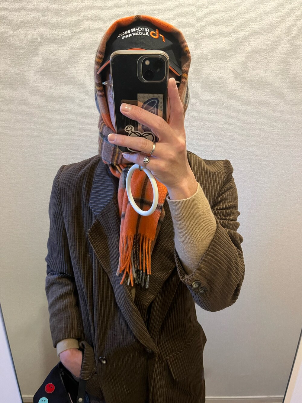 ブラウン系のテーラードジャケット、ブラック系のハンドバッグを着用したメンズの冬コーディネートの2枚目の写真