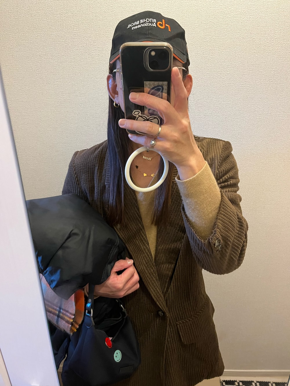 ブラウン系のテーラードジャケット、ブラック系のハンドバッグを着用したメンズの冬コーディネートの4枚目の写真