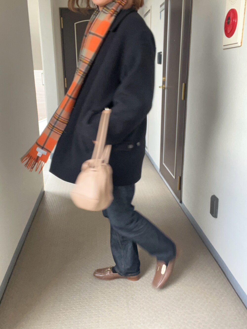 ブラック系のステンカラーコート、その他のデニムパンツを着用したメンズの冬コーディネートの4枚目の写真