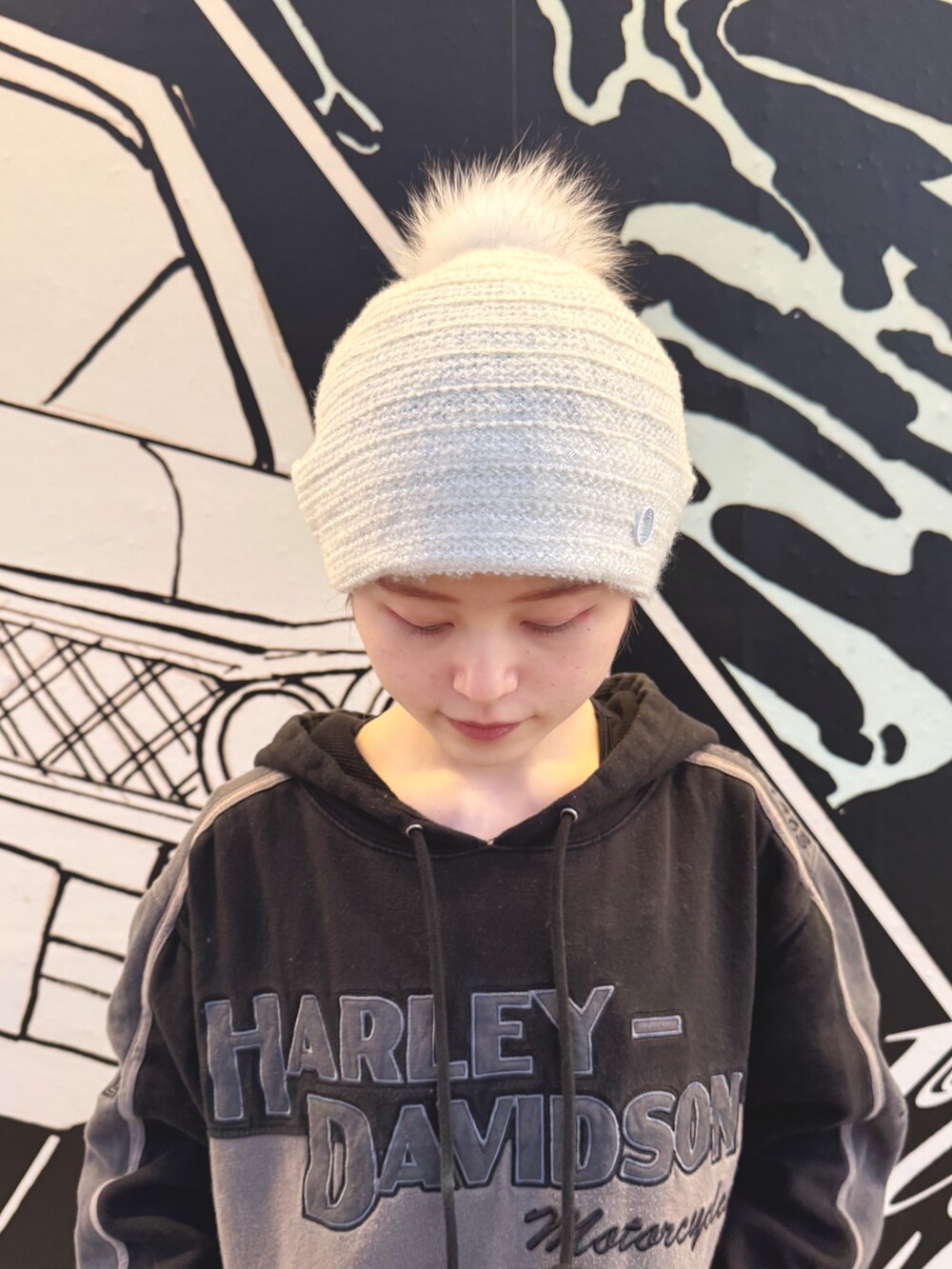 ホワイト系のニットキャップ/ビーニーを着用したレディースの冬コーディネートの2枚目の写真