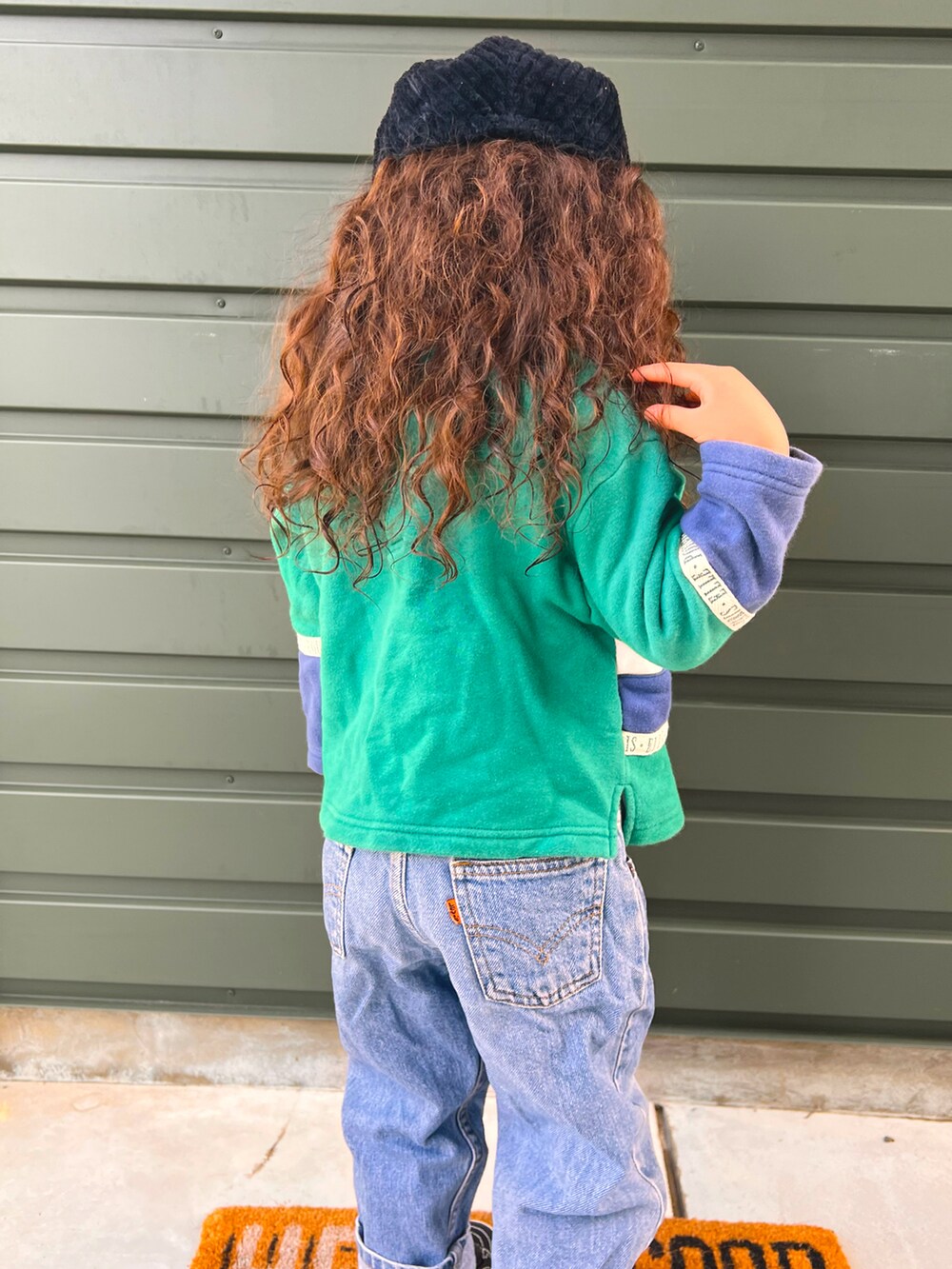 グリーン系のトップス、ブルー系のパンツ、ブラック系のシューズを着用したキッズの冬コーディネートの2枚目の写真