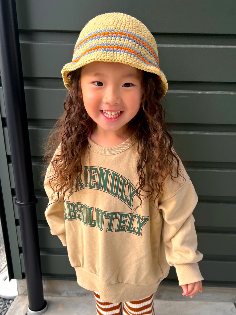 ベージュ系のスウェット、ブラウン系のパンツ、ブラック系のスニーカーを着用したキッズの春コーディネートの3枚目の写真