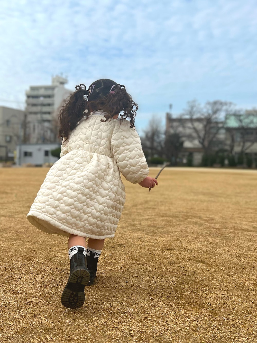 ホワイト系のワンピース/ドレス、ブラック系のシューズ、ホワイト系のソックス/靴下を着用したキッズの冬コーディネートの2枚目の写真