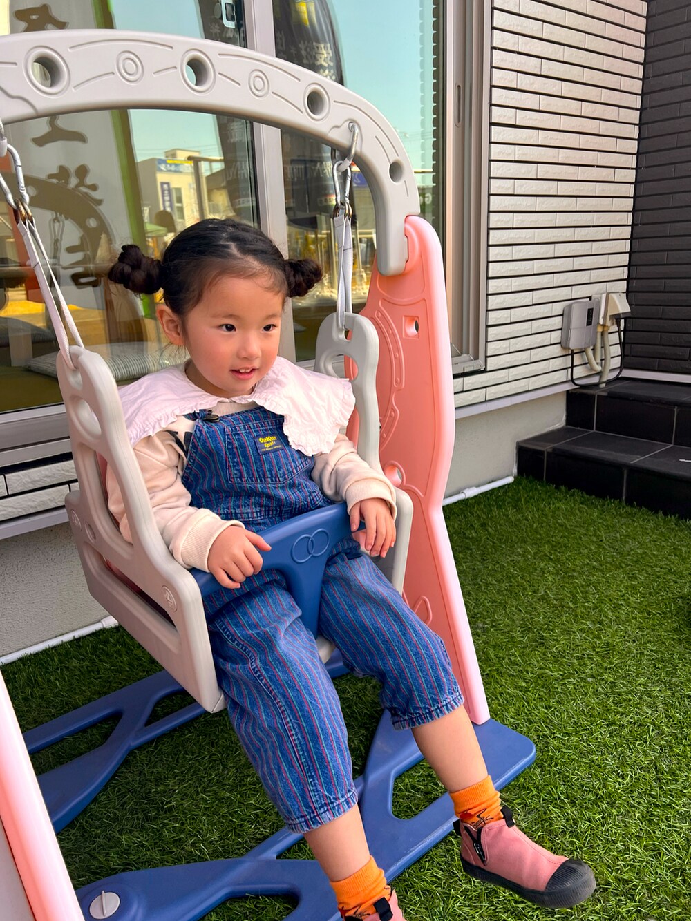 ピンク系のシューズ、ブルー系のオールインワン・サロペットを着用したキッズの冬コーディネートの3枚目の写真