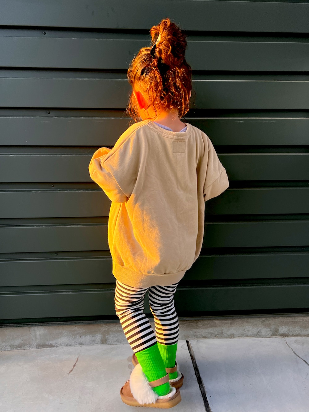 ベージュ系のスウェット、ブラック系のパンツ、ベージュ系のシューズを着用したキッズの春コーディネートの2枚目の写真