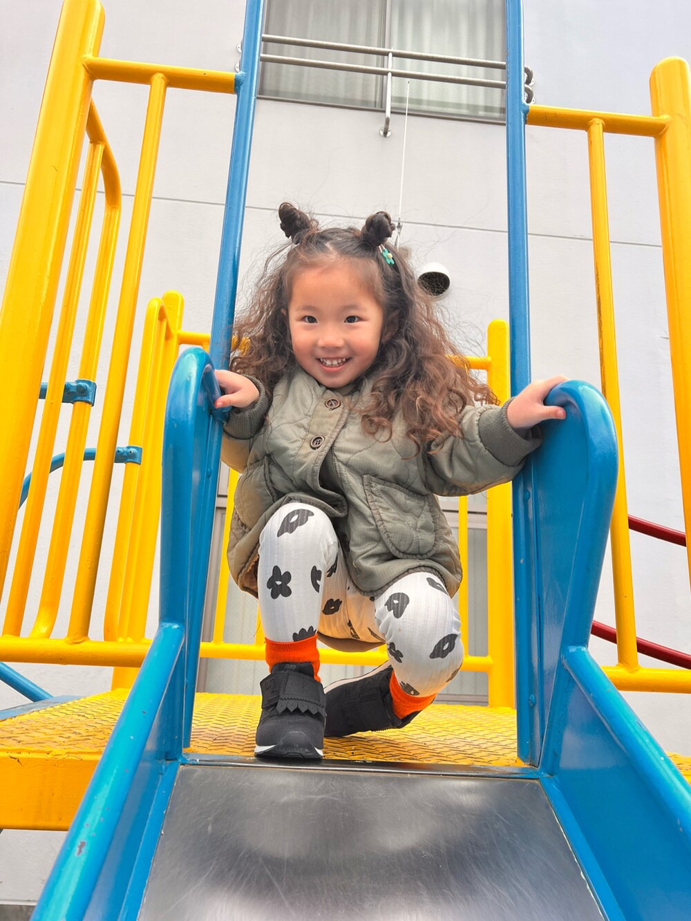 ホワイト系のパンツ、ブラック系のスニーカー、ベージュ系のスウェットを着用したキッズの冬コーディネートの2枚目の写真