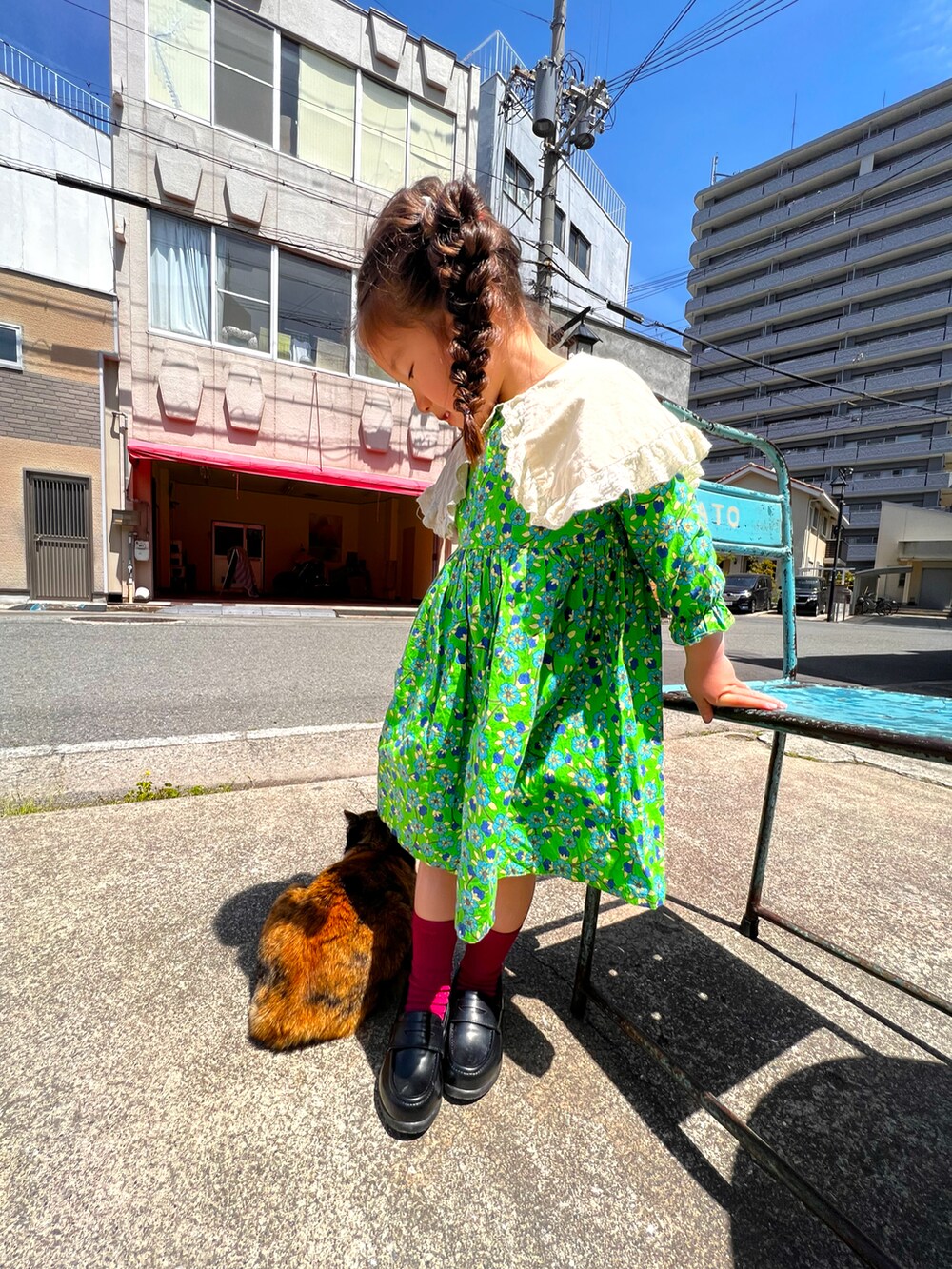グリーン系のワンピース/ドレス、ブラック系のシューズ、ピンク系のソックス/靴下を着用したキッズの春コーディネートの2枚目の写真