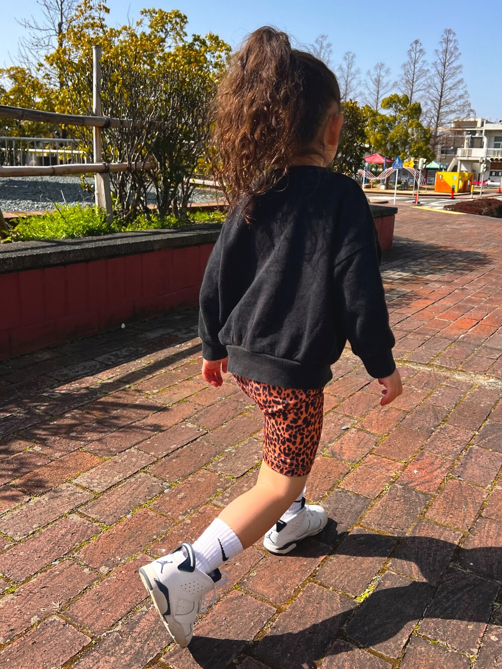 ホワイト系のシューズ、ブラウン系のパンツ、ブラック系のスウェットを着用したキッズの春コーディネートの2枚目の写真