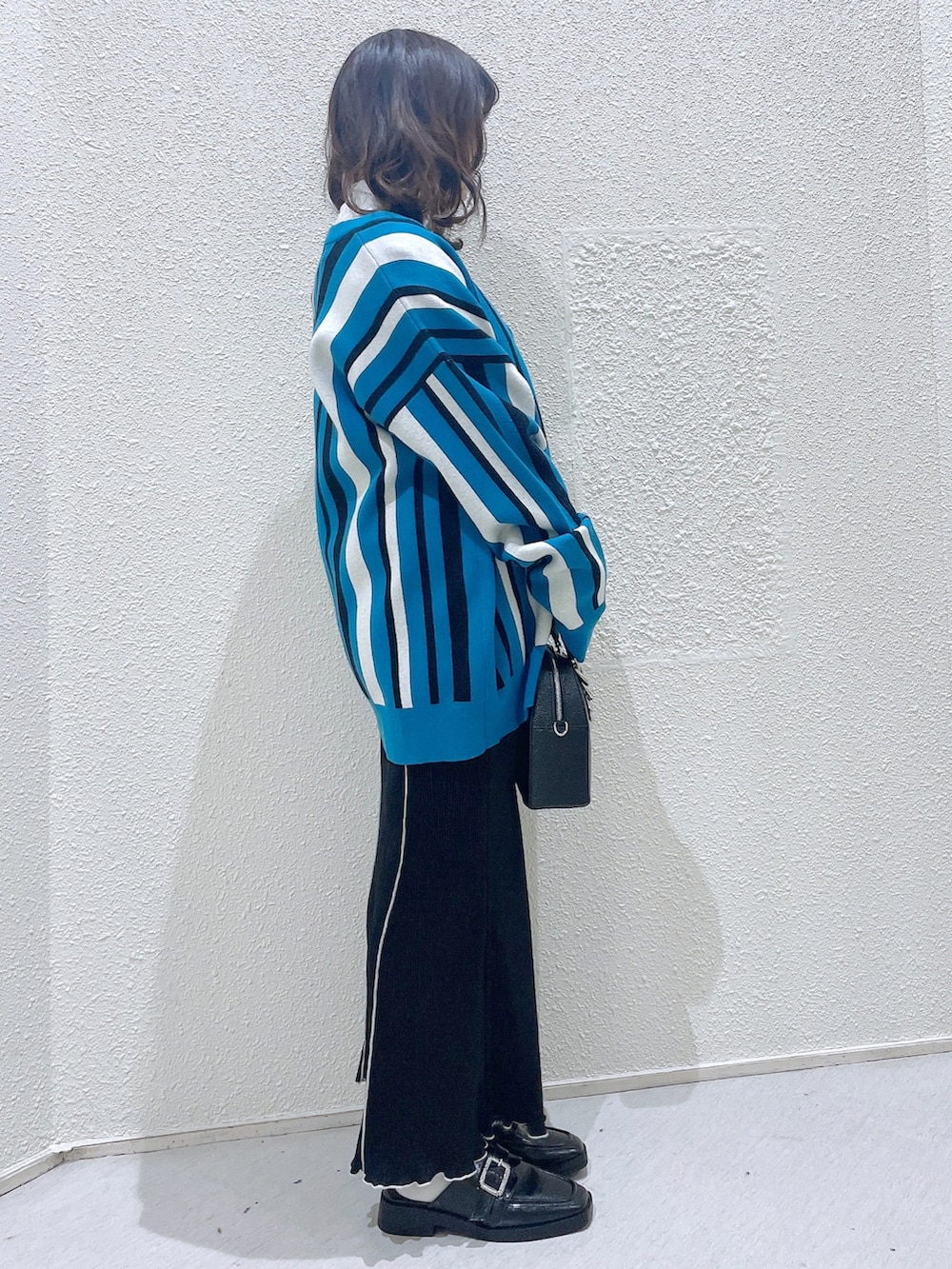 ブルー系のカーディガン/ボレロ、グリーン系のTシャツ/カットソー、ブラック系のショルダーバッグを着用したレディースの冬コーディネートの3枚目の写真