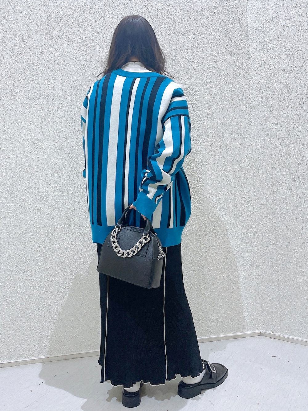 ブルー系のカーディガン/ボレロ、グリーン系のTシャツ/カットソー、ブラック系のショルダーバッグを着用したレディースの冬コーディネートの4枚目の写真