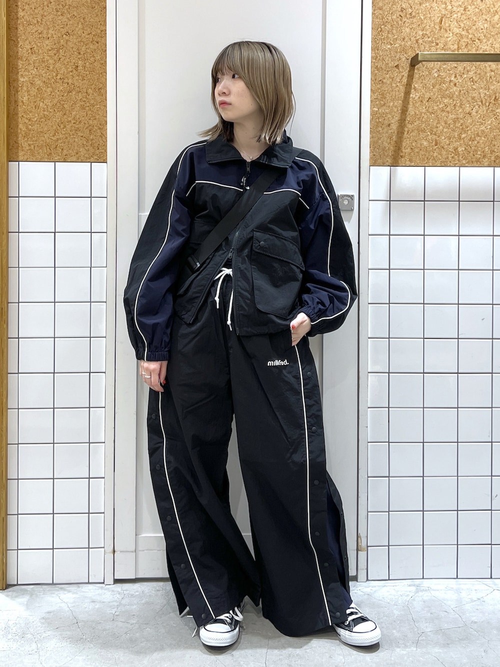 ブラック系のナイロンジャケット、ブラック系のその他パンツ、ブラック系のショルダーバッグを着用したレディースの冬コーディネートの2枚目の写真