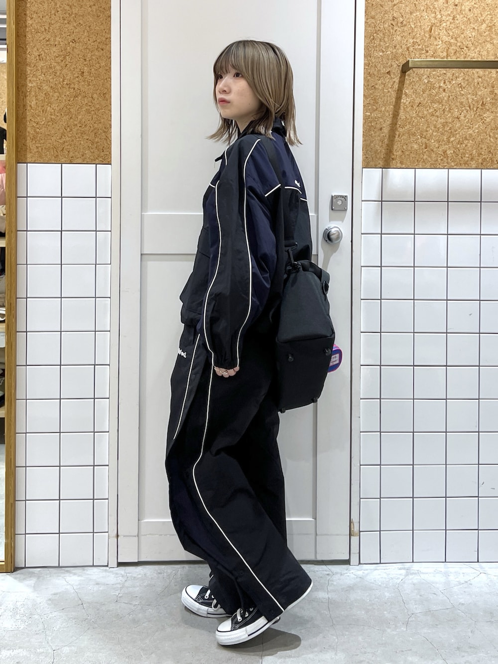 ブラック系のナイロンジャケット、ブラック系のその他パンツ、ブラック系のショルダーバッグを着用したレディースの冬コーディネートの4枚目の写真