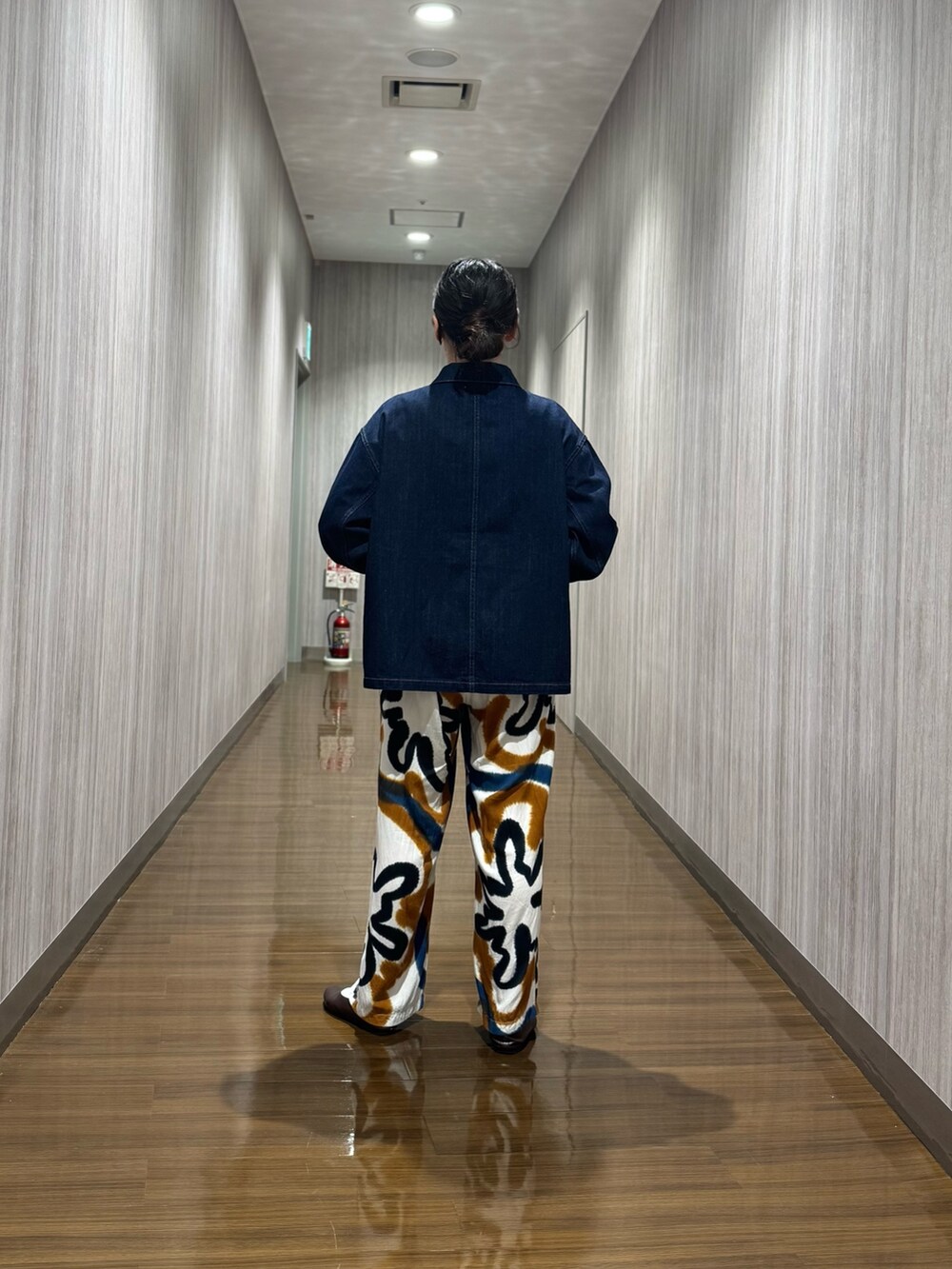 ブルー系のデニムジャケット、ブラウン系のパンプスを着用したレディースの秋コーディネートの3枚目の写真