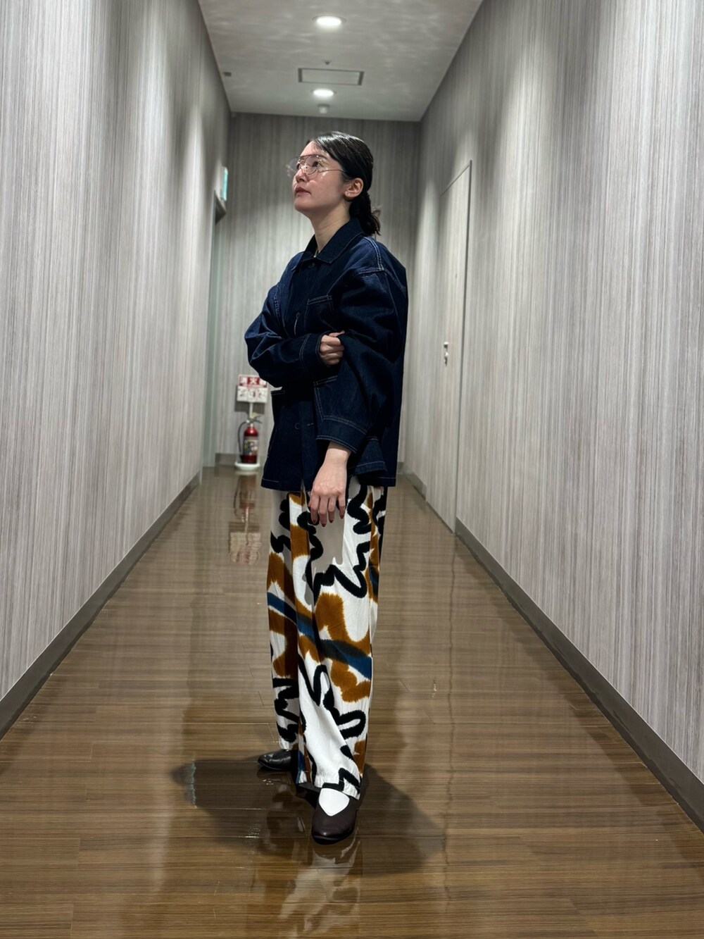 ブルー系のデニムジャケット、ブラウン系のパンプスを着用したレディースの秋コーディネートの2枚目の写真