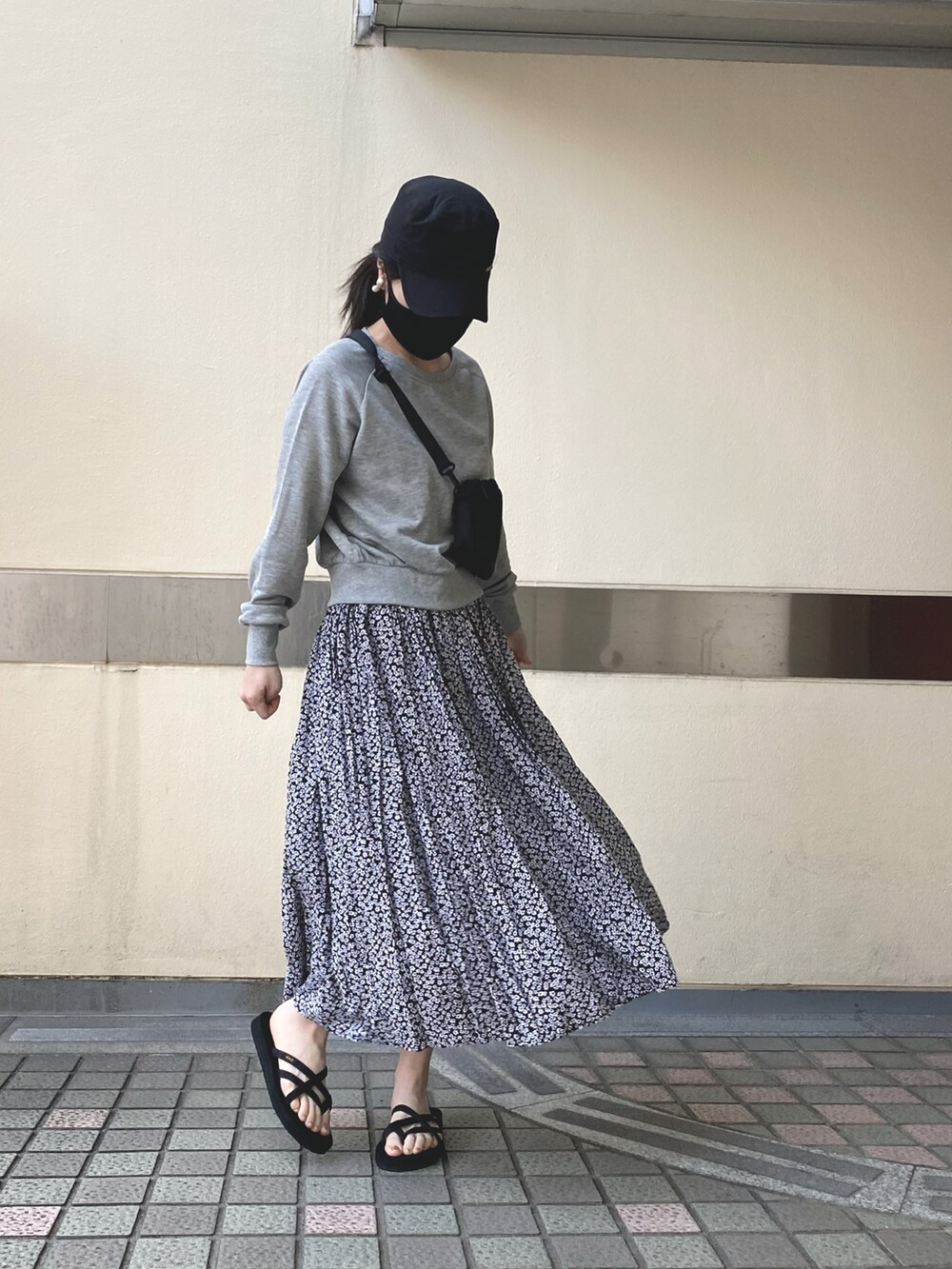 ブラック系のサンダル、ブラック系のスカート、グレー系のスウェットを着用したレディースの春コーディネートの2枚目の写真
