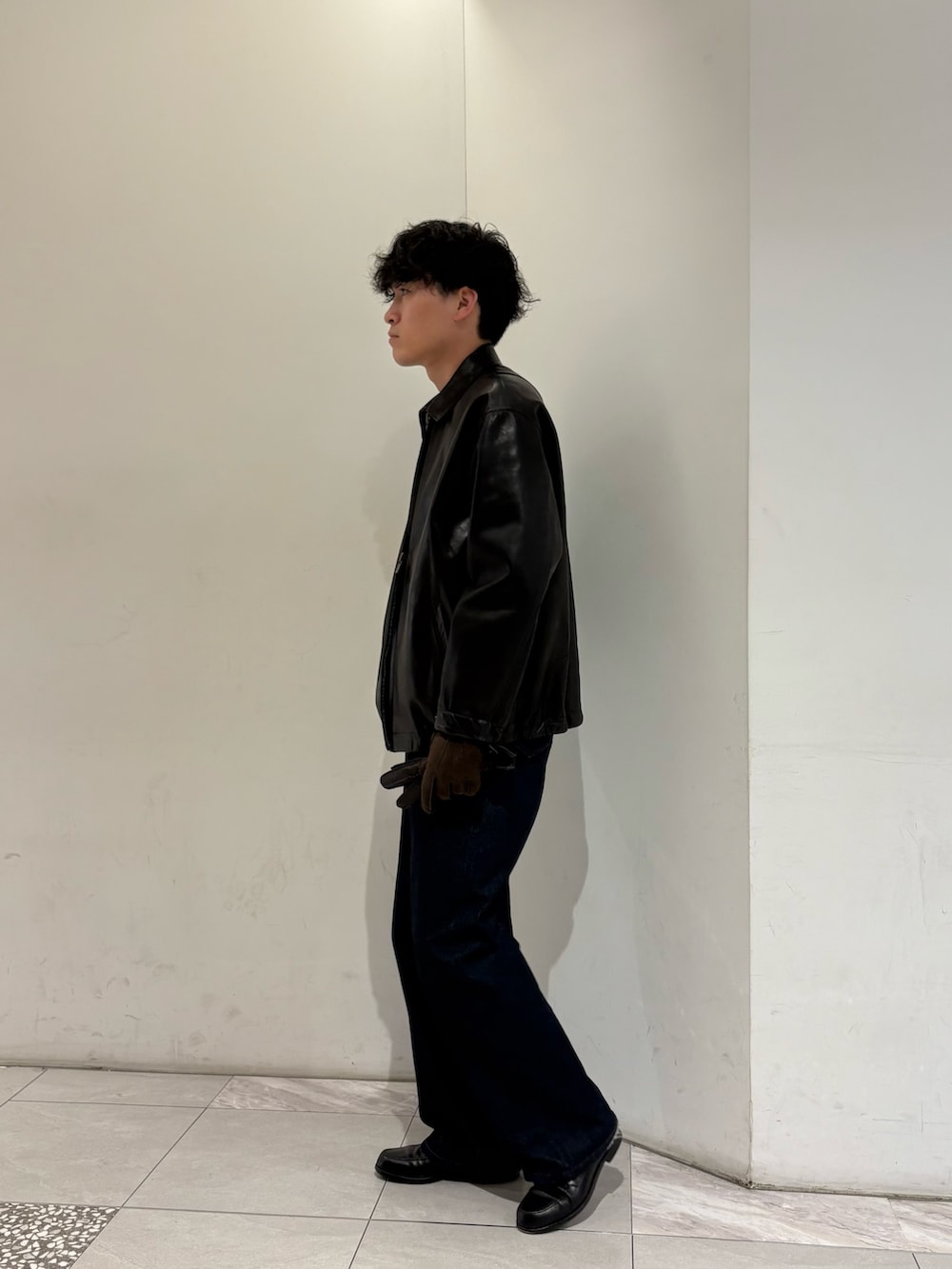 ブラック系のテーラードジャケット、ブラウン系の手袋を着用したメンズの冬コーディネートの5枚目の写真