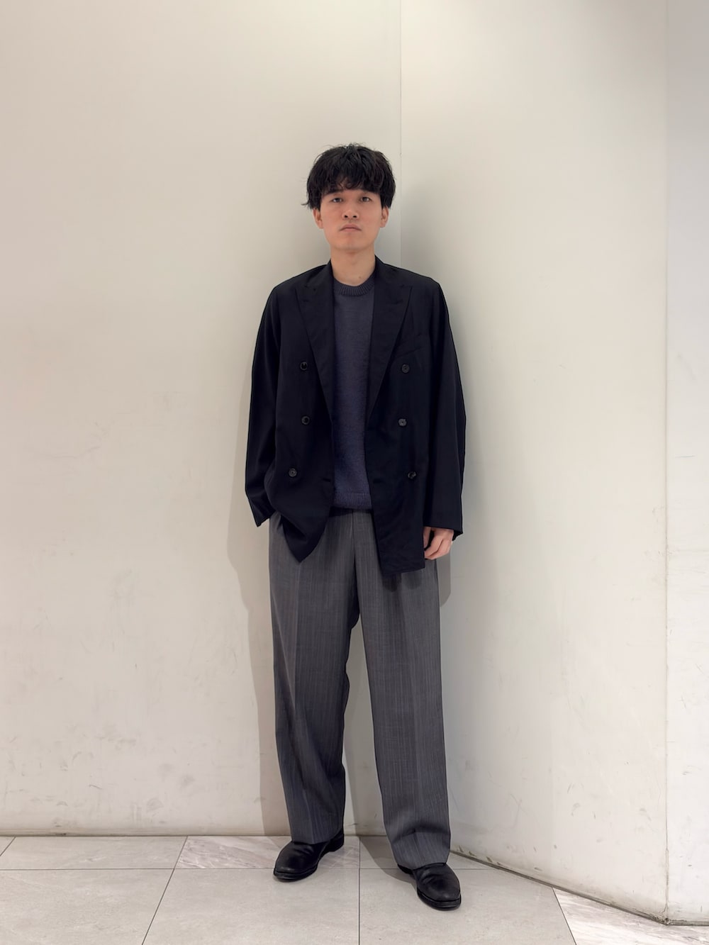 ブラック系のブーツ、グレー系のその他パンツ、ブルー系のニット/セーターを着用したメンズの春コーディネートの2枚目の写真