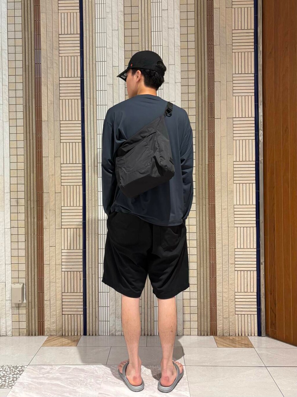 ブルー系のその他パンツ、ブラック系のショルダーバッグ、シルバー系のサンダルを着用したメンズの夏コーディネートの3枚目の写真