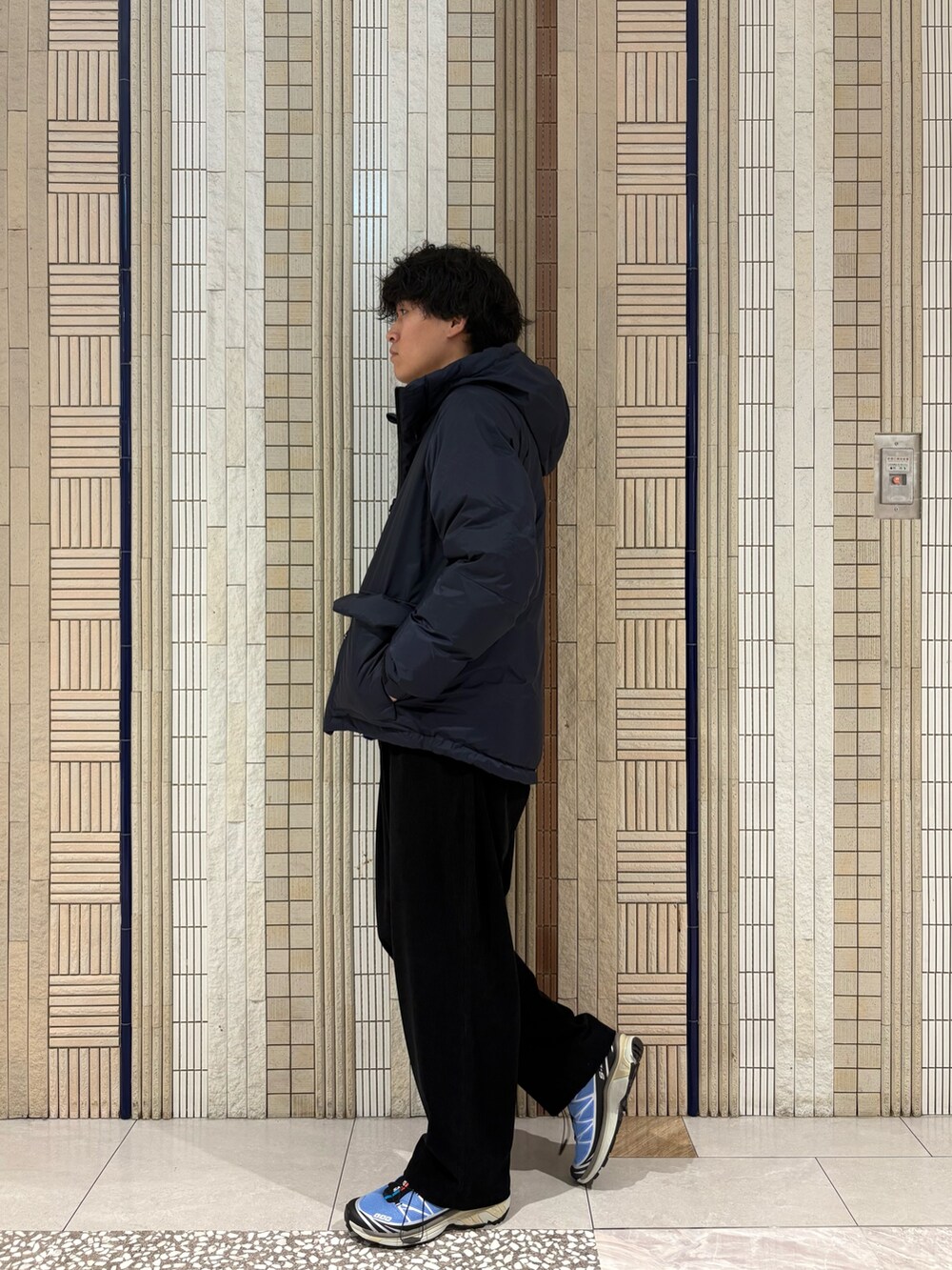 ブルー系のダウンジャケット/コート、パープル系のニット/セーター、ブルー系のその他パンツを着用したメンズの秋コーディネートの5枚目の写真