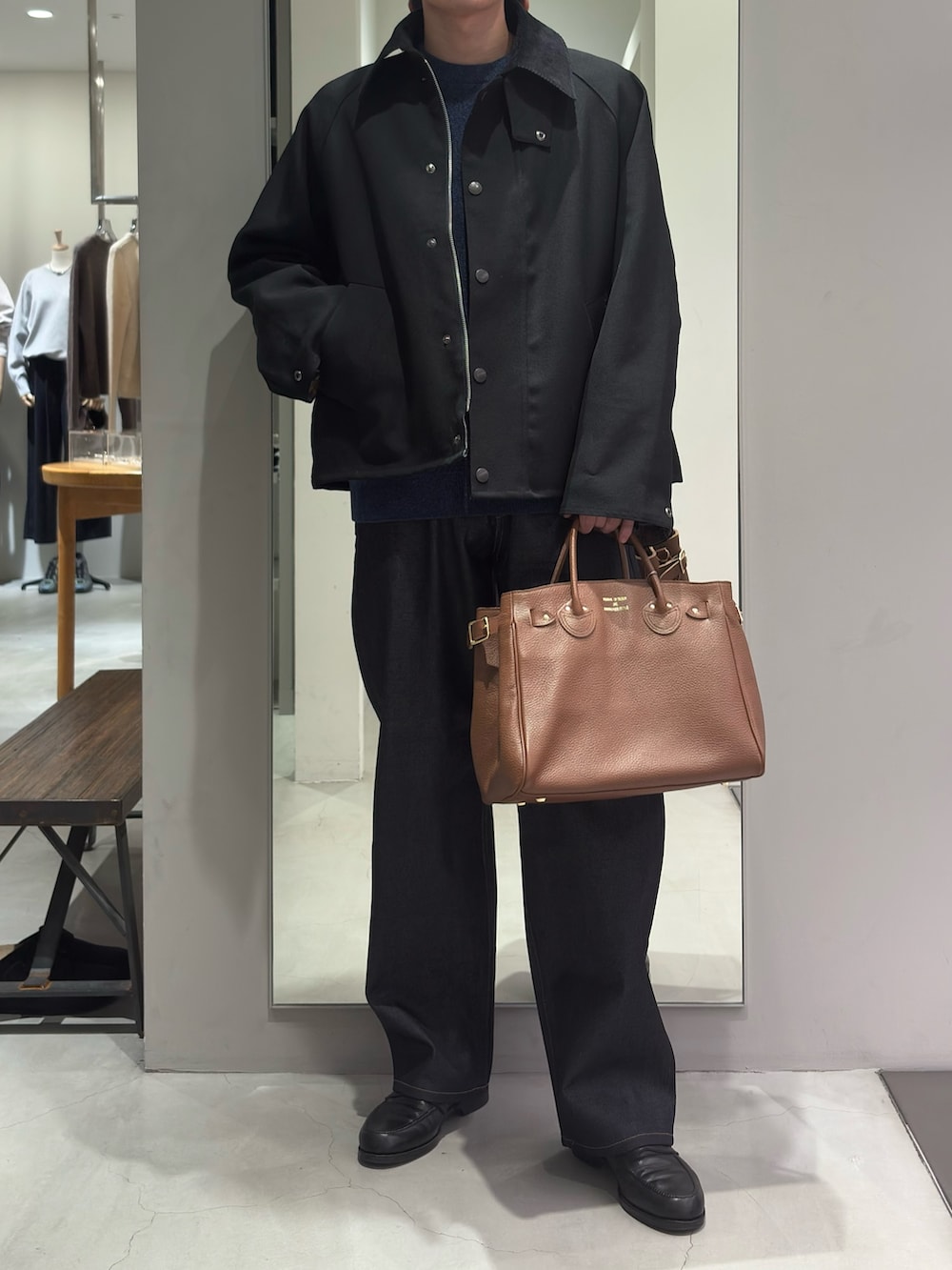 ブラック系のその他アウター、ブルー系のニット/セーター、ブルー系のデニムパンツを着用したメンズの秋コーディネートの2枚目の写真