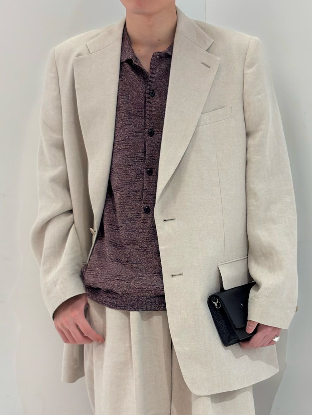 ブラウン系のニット/セーター、ベージュ系のその他パンツ、ブラック系のブーツを着用したメンズの春コーディネートの3枚目の写真