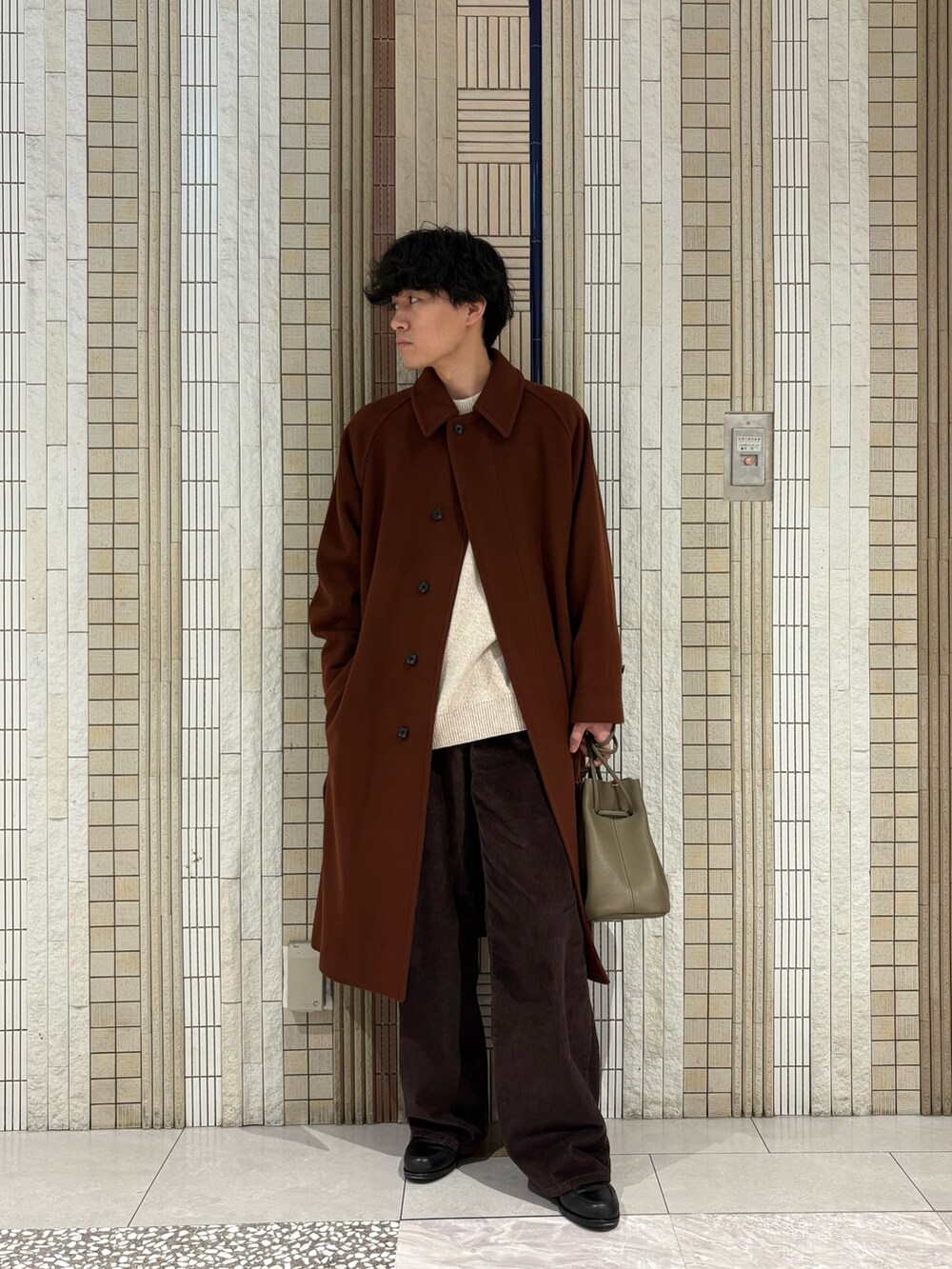 ブラウン系のステンカラーコート、ホワイト系のニット/セーター、ベージュ系のその他雑貨を着用したメンズの冬コーディネートの3枚目の写真
