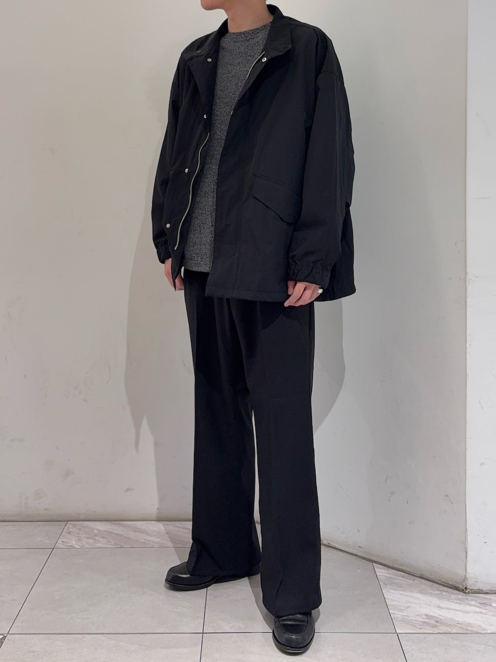 ブラック系のその他アウター、グレー系のニット/セーター、ブラック系のその他パンツを着用したメンズの冬コーディネートの2枚目の写真