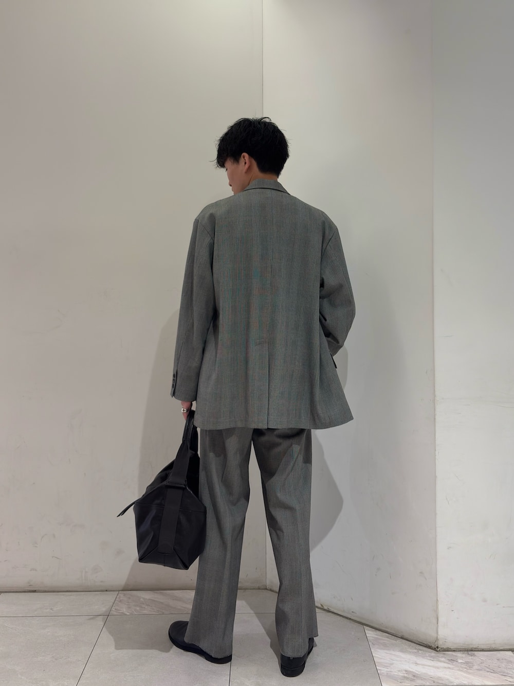 イエロー系のニット/セーター、ブラック系のブーツを着用したメンズの春コーディネートの5枚目の写真