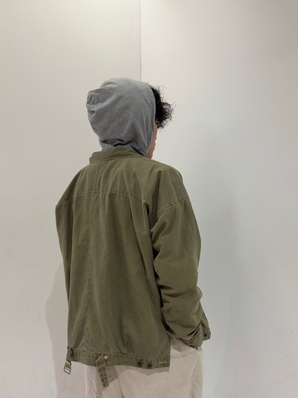 グリーン系のブルゾン、ブラック系のブーツを着用したメンズの春コーディネートの4枚目の写真