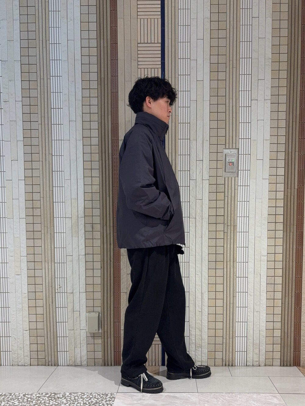 グリーン系のその他アウター、ブラック系のニット/セーター、ブラック系のその他パンツを着用したメンズの秋コーディネートの6枚目の写真