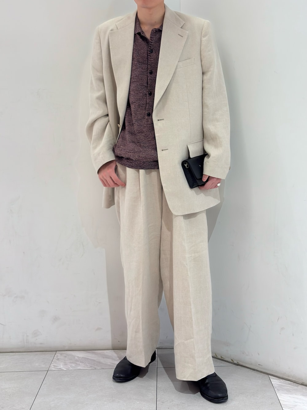 ブラウン系のニット/セーター、ベージュ系のその他パンツ、ブラック系のブーツを着用したメンズの春コーディネートの2枚目の写真