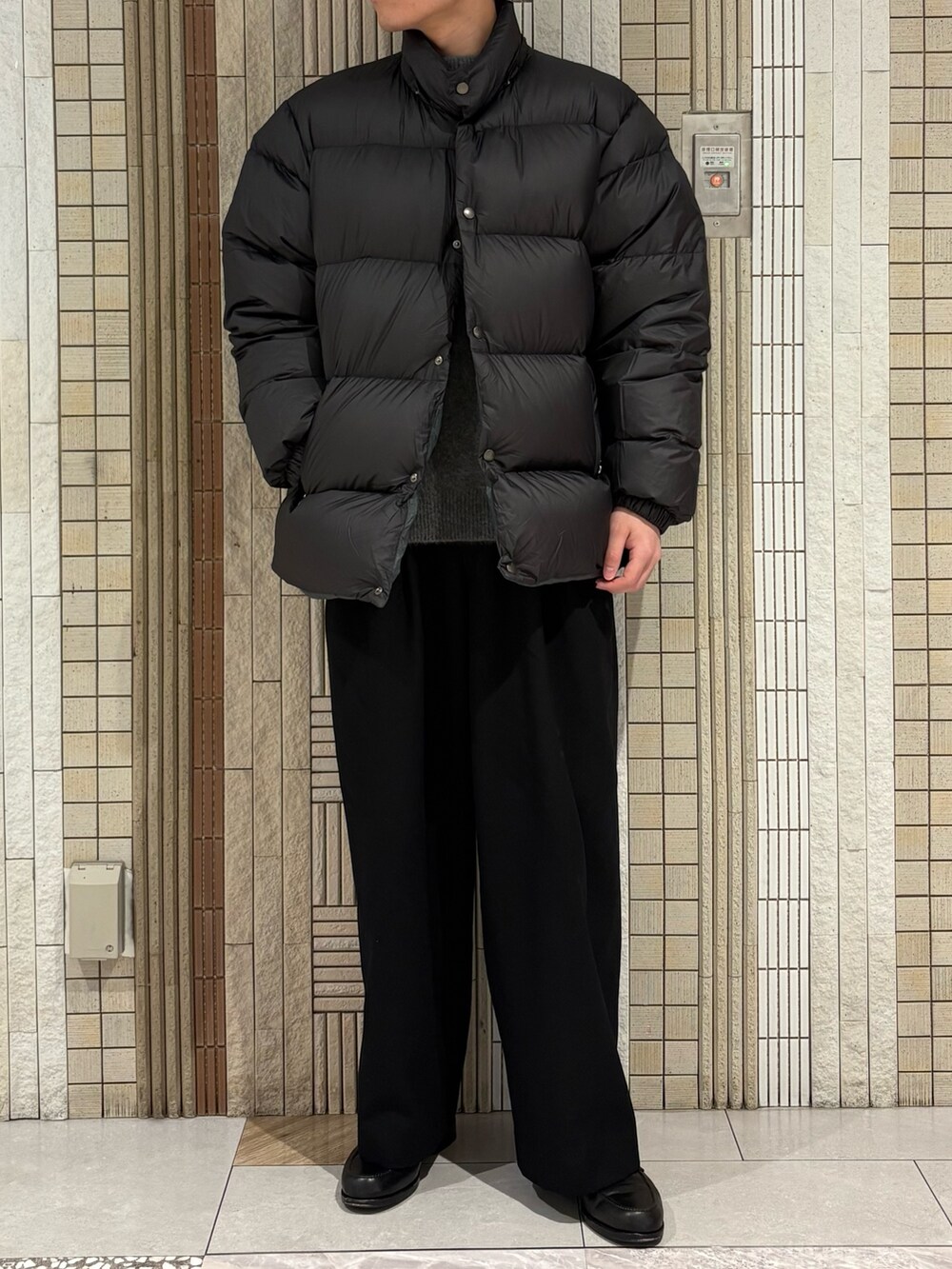 グリーン系のダウンジャケット/コート、グレー系のニット/セーターを着用したメンズの冬コーディネートの3枚目の写真