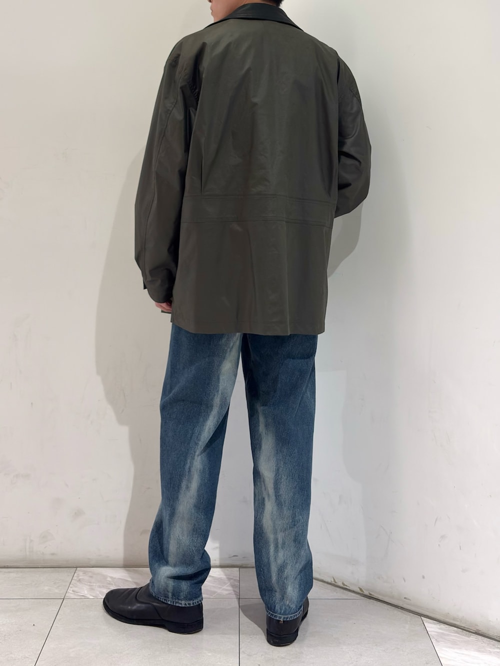 グリーン系のその他アウター、イエロー系のニット/セーター、ブルー系のデニムパンツを着用したメンズの春コーディネートの6枚目の写真