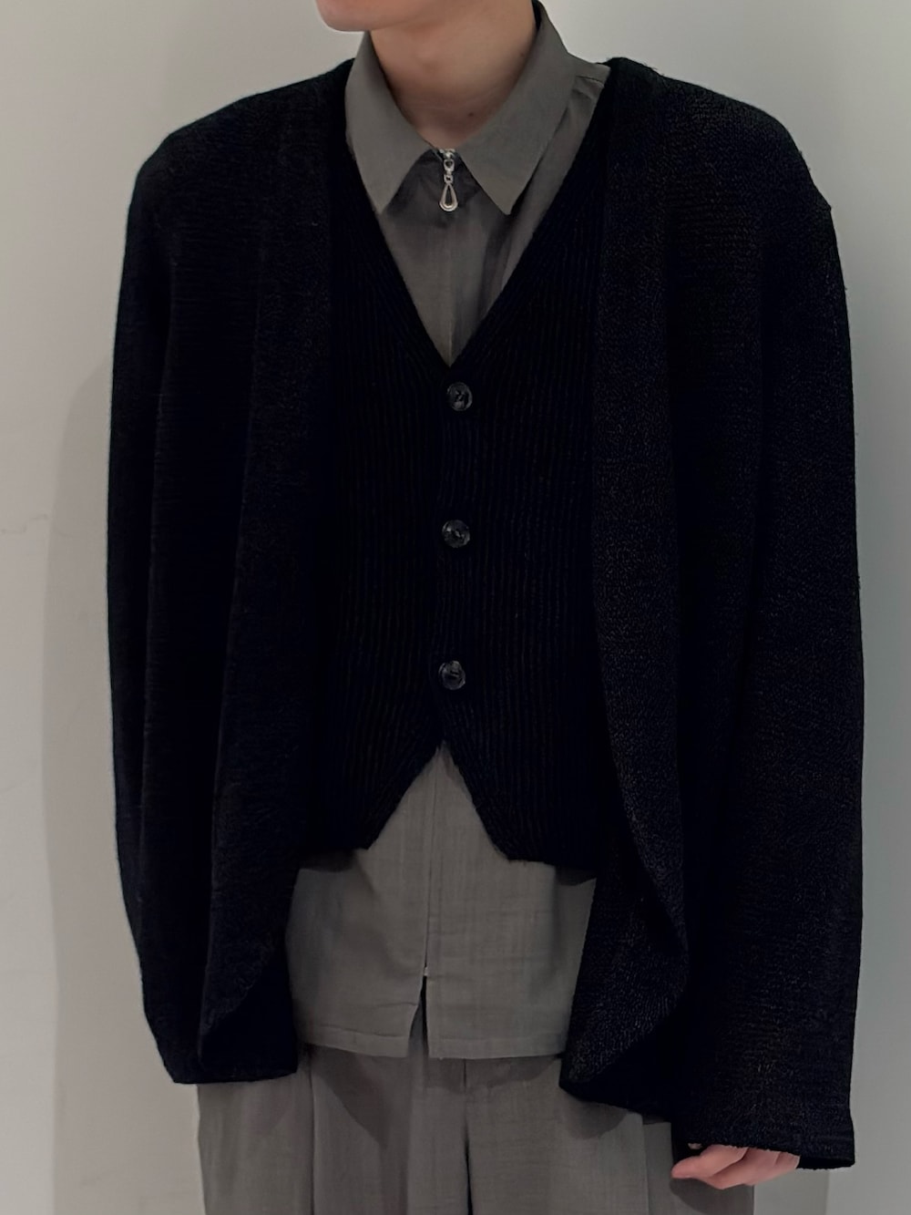 ブラック系のニット/セーター、ブラック系のベスト、グレー系のブルゾンを着用したメンズの春コーディネートの3枚目の写真