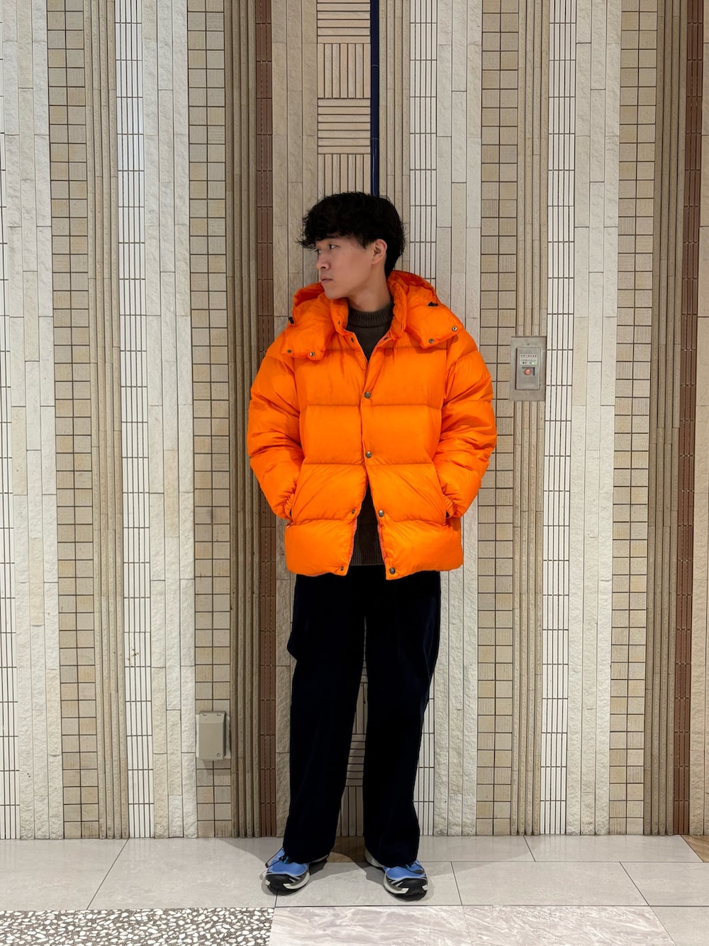 ブルー系のその他パンツ、ブルー系のスニーカー、オレンジ系のダウンジャケット/コートを着用したメンズの秋コーディネートの5枚目の写真