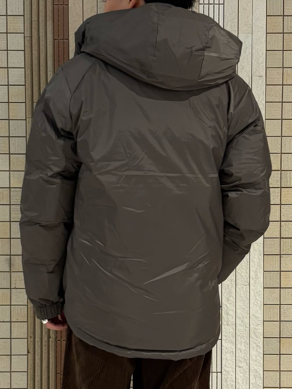 グレー系のダウンジャケット/コート、レッド系のニット/セーター、ブラウン系のその他パンツを着用したメンズの秋コーディネートの8枚目の写真