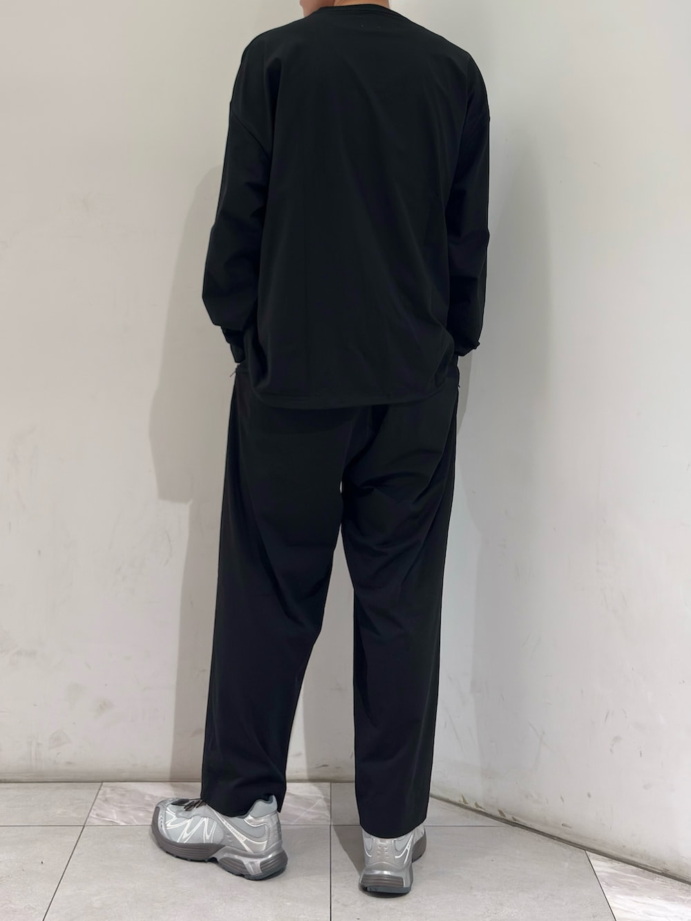 ブラック系のTシャツ/カットソー、ブラック系のその他パンツ、シルバー系のスニーカーを着用したメンズの春コーディネートの6枚目の写真